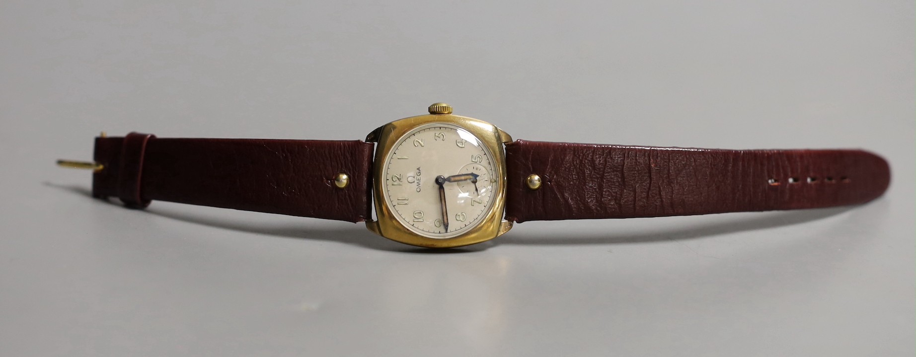 A gentleman's 9ct gold Omega cushion case wrist watch with silvered Arabic dial, monogrammed on the back and dated 1938